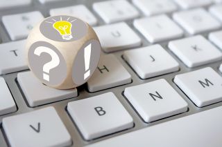 figure_photo: Würfel auf Tastatur mit Rufzeichen und Fragezeichen