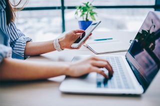 © BullRun - Adobe Stock.com figure_photo: Frau mit Smartphone und Laptop
