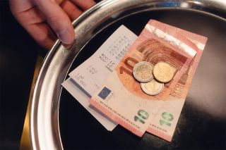 figure_photo: Silbernes Tablett mit Trinkgeld und Rechnung darauf