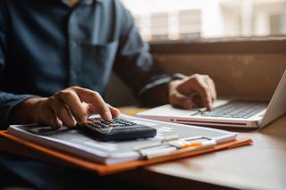 figure_photo: Person mit Taschenrechner und Laptop